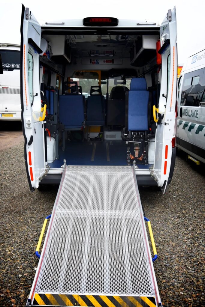 The back of a non-emergency ambulance with doors open and ramp down