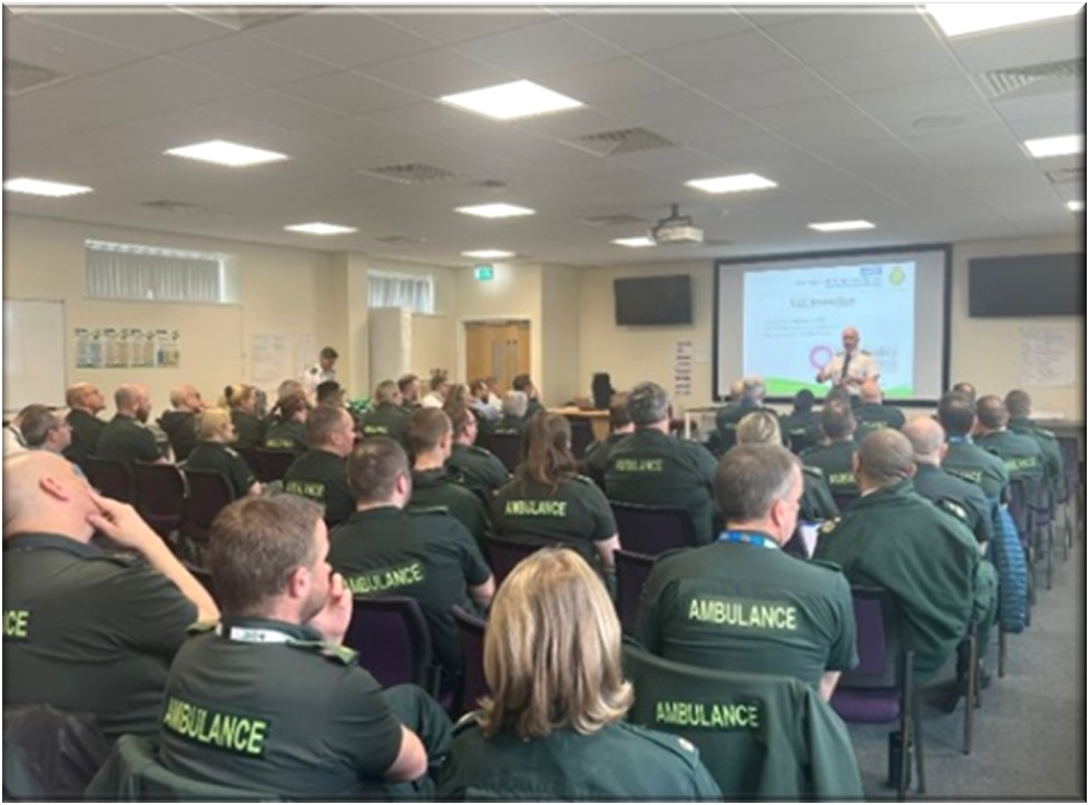 A group of ambulance staff in a classroom setting.
