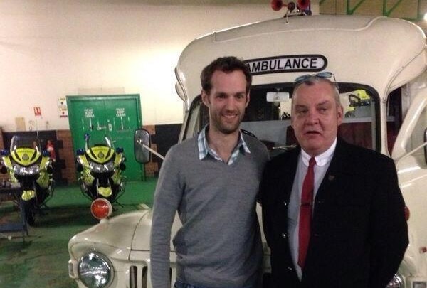 Tim Atherton and Tom McCann stand in front of an old white ambulance