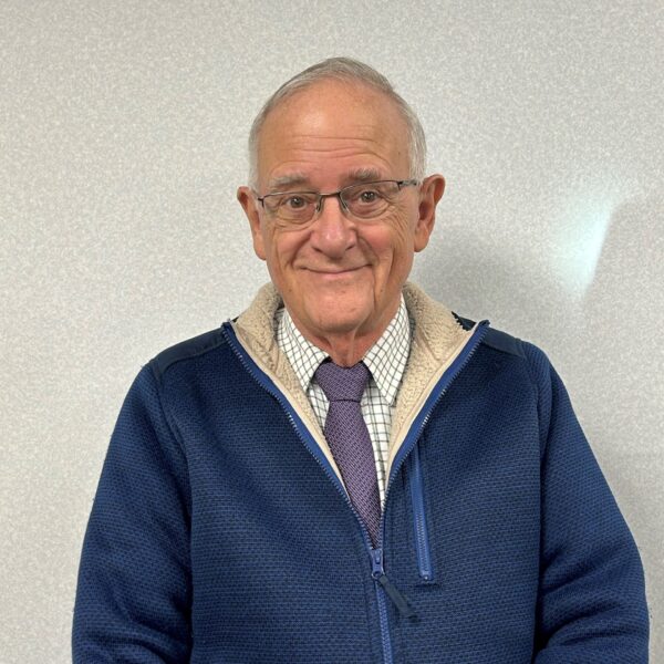 a man wearing glasses, a fleece jacket with a shirt and tie