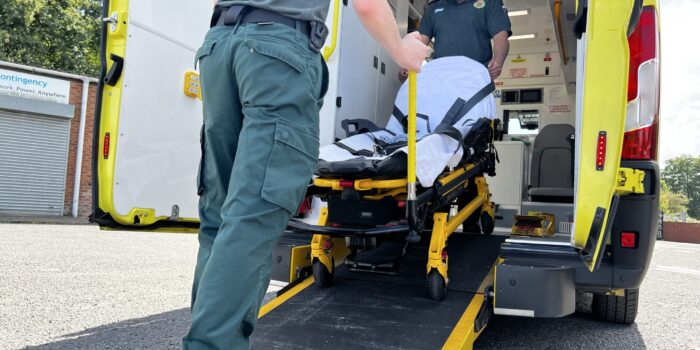 An ambulance crew taking a stretcher off an ambulance