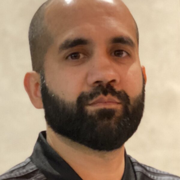 Portrait photo of Non-executive director Mohammed Fessal, with a beard and smiling at camera.