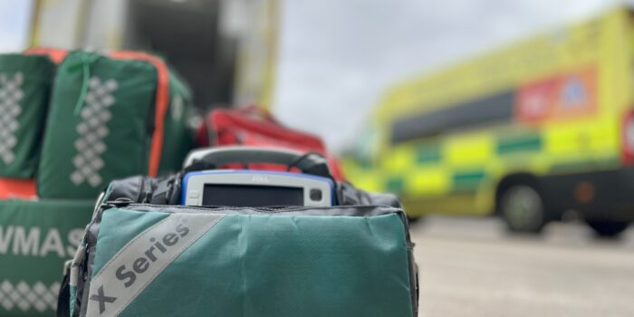 Response bags on floor in foreground with two ambulances in background