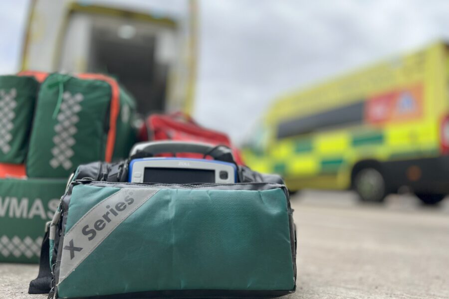 Response bags on floor in foreground with two ambulances in background