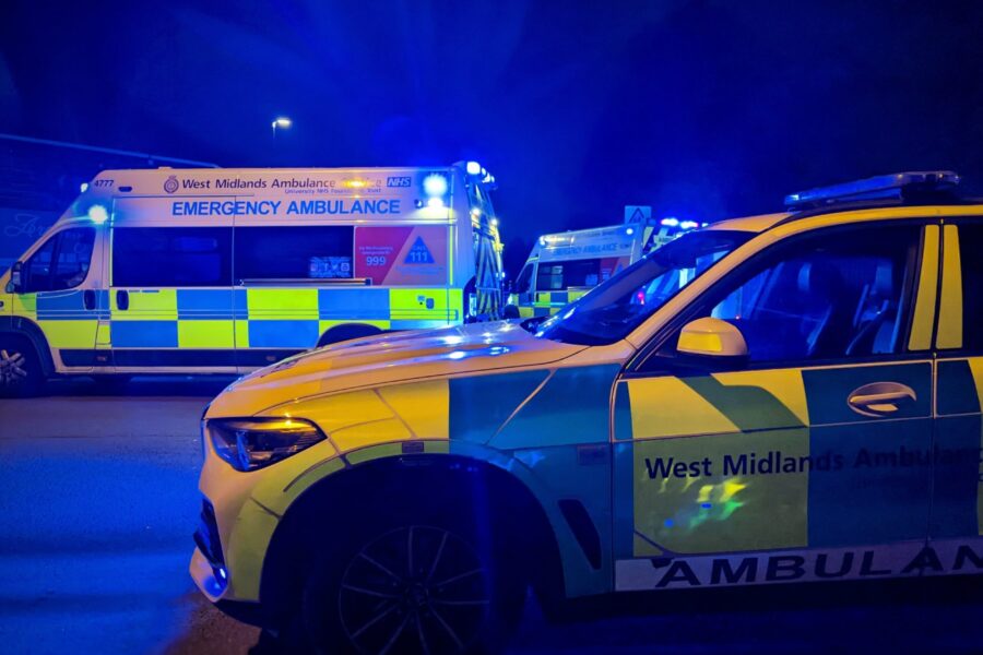 Two ambulances and an ambulance officer car at night