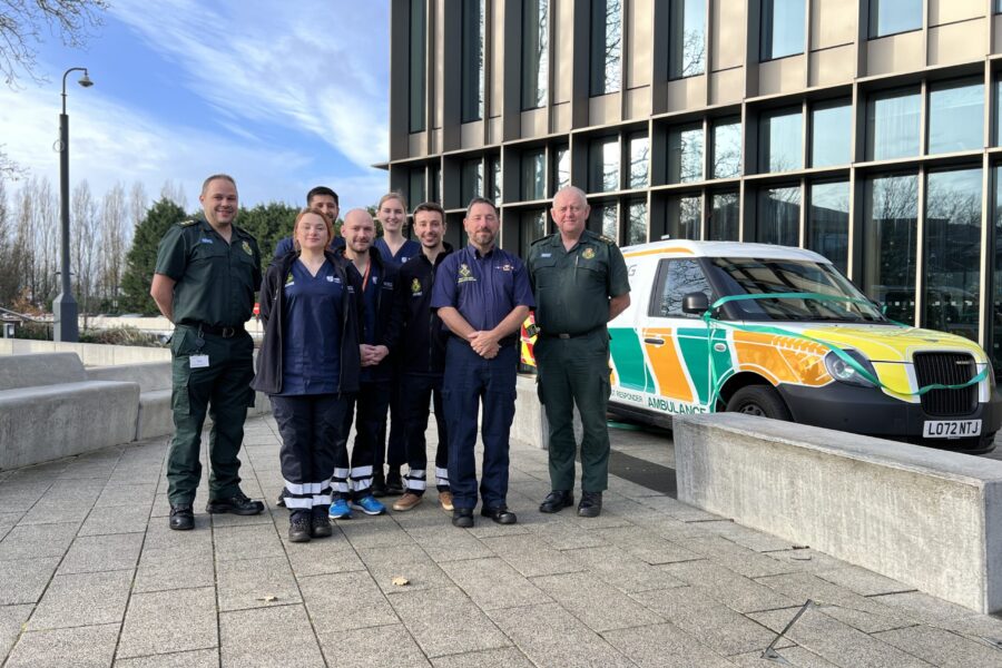 Six Warwick Medical School Community First Responders standing with WMAS paramedics next to their response car.