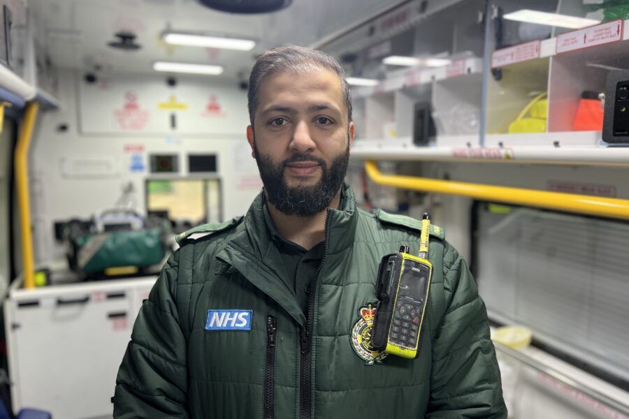 Erdington Paramedics charity cycle - photo of paramedic called Adi smiling at camera in uniform standing in back of ambulance.